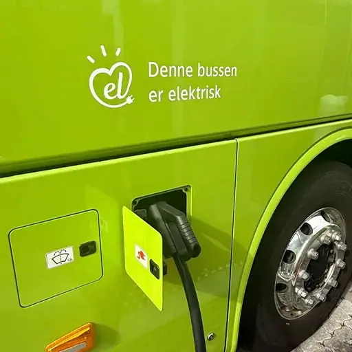 Tenix Value: Smart Sustainability Close-up of a bright green electric bus plugged into a charging station, representing Smart Sustainability.