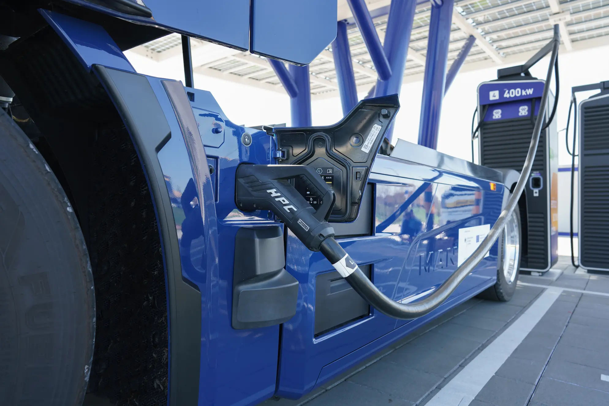 Setter inaktiv infrastruktur i arbeid for partnere Close-up of a heavy-duty electric truck connected to a High-Power Charger (HPC) at a charging station, illustrating shared infrastructure.