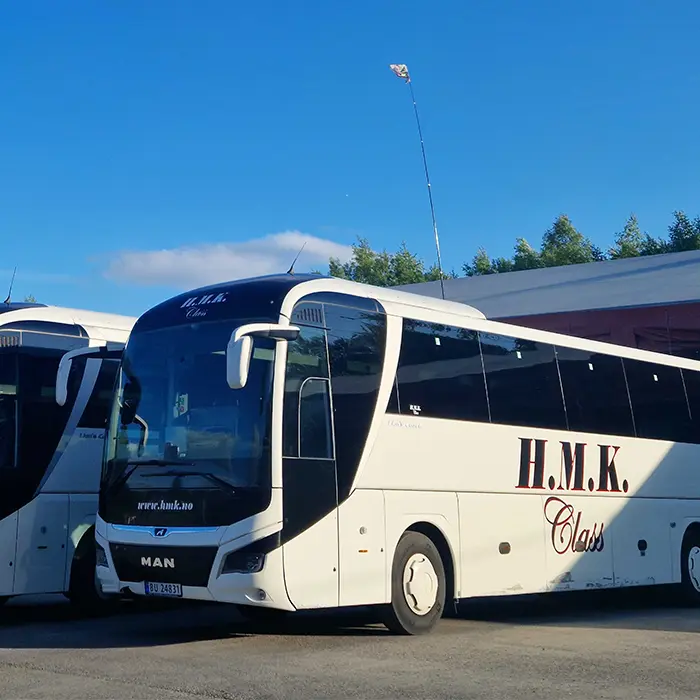 Simple, Reliable Control for Private Operators Private fleet operator managing electric bus charging and maintenance using a handheld control device in a depot.